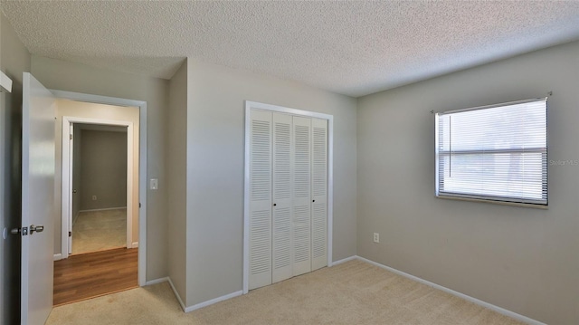 1802 N Fern Palm Dr, Edgewater, FL 32132 - unfurnished bedroom with a closet, carpet flooring, a textured ceiling, and baseboards