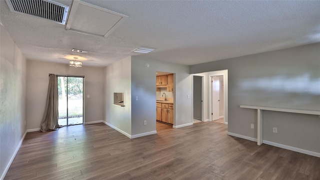 1802 N Fern Palm Dr, Edgewater, FL 32132 - empty room with a sink, a textured ceiling, wood finished floors, and baseboards