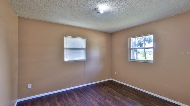 1802 N Fern Palm Dr, Edgewater, FL 32132 - unfurnished room with dark wood finished floors, a textured ceiling, and baseboards