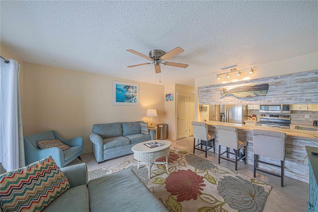 3615 S Atlantic Ave Unit 211, Daytona Beach, FL 32118 - living area with ceiling fan, light tile patterned flooring, and a textured ceiling