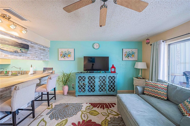 3615 S Atlantic Ave Unit 211, Daytona Beach, FL 32118 - living area featuring a ceiling fan, baseboards, a textured ceiling, and light tile patterned flooring