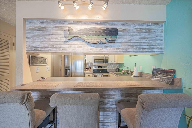 3615 S Atlantic Ave Unit 211, Daytona Beach, FL 32118 - bar featuring stainless steel appliances, a sink, and a textured ceiling