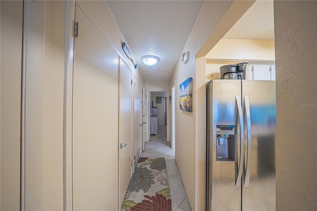3615 S Atlantic Ave Unit 211, Daytona Beach, FL 32118 - corridor featuring a textured ceiling, a textured wall, and light tile patterned flooring