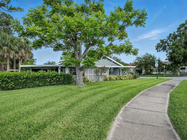 2 Birdie Dr, New Smyrna Beach, FL 32168 - view of front facade featuring a front lawn and board and batten siding
