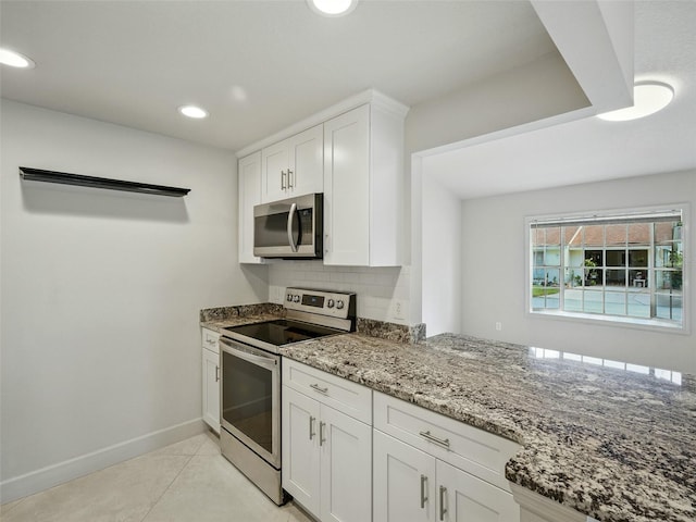 2 Birdie Dr, New Smyrna Beach, FL 32168 - kitchen with stainless steel appliances, stone counters, white cabinets, decorative backsplash, and recessed lighting