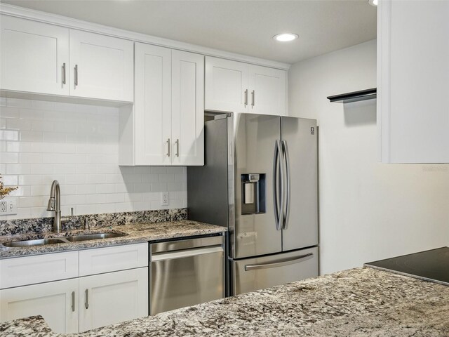 2 Birdie Dr, New Smyrna Beach, FL 32168 - kitchen with appliances with stainless steel finishes, white cabinets, light stone countertops, decorative backsplash, and recessed lighting