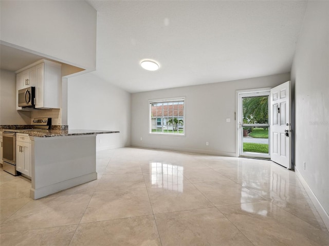 2 Birdie Dr, New Smyrna Beach, FL 32168 - kitchen featuring appliances with stainless steel finishes, dark stone counters, open floor plan, and white cabinetry