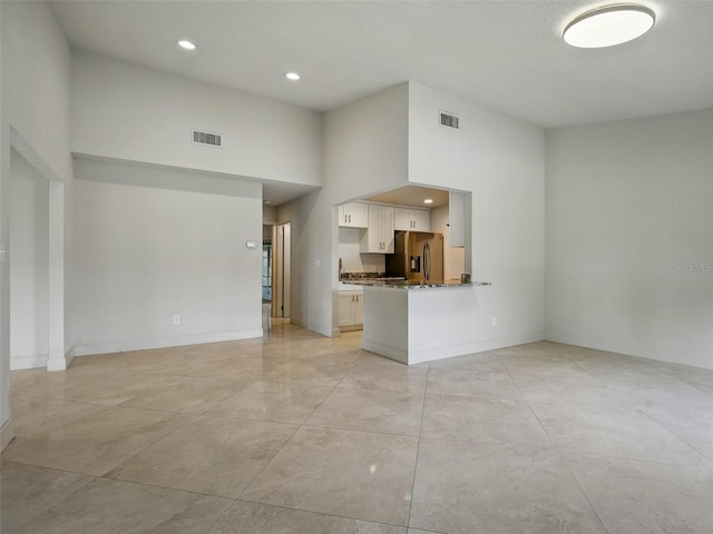 2 Birdie Dr, New Smyrna Beach, FL 32168 - unfurnished living room with a high ceiling and recessed lighting