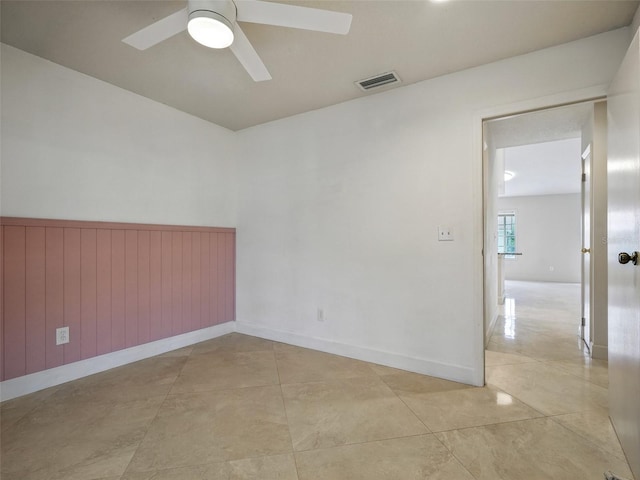 2 Birdie Dr, New Smyrna Beach, FL 32168 - spare room featuring ceiling fan, a wainscoted wall, and light tile patterned flooring