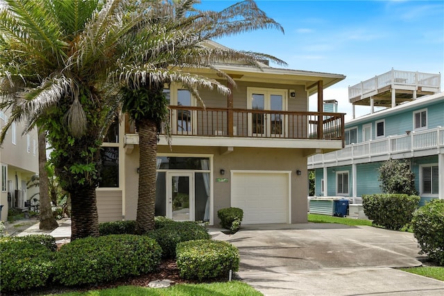6956 Turtlemound Rd, New Smyrna Beach, FL 32169 - view of front facade with a balcony, driveway, an attached garage, and stucco siding
