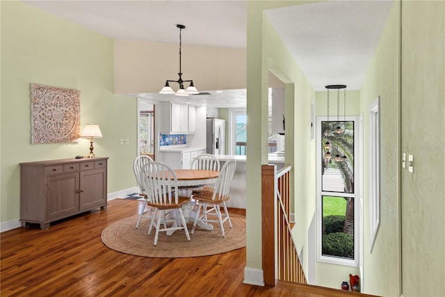 6956 Turtlemound Rd, New Smyrna Beach, FL 32169 - dining area featuring wood finished floors, vaulted ceiling, and a chandelier