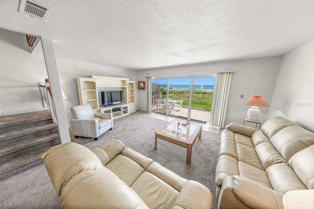 4777 S Atlantic Ave Unit B2, Port Orange, FL 32127 - carpeted living room featuring a textured ceiling and stairs