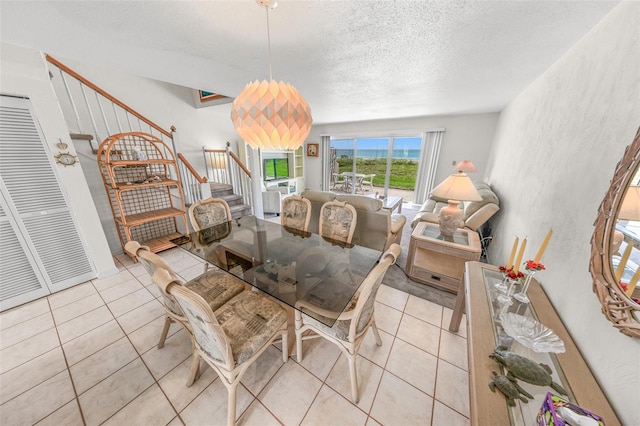 4777 S Atlantic Ave Unit B2, Port Orange, FL 32127 - dining space featuring stairway, a textured ceiling, tile patterned flooring, and a textured wall