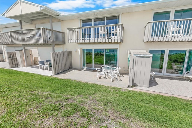 4777 S Atlantic Ave Unit B2, Port Orange, FL 32127 - rear view of property featuring stucco siding, a patio area, a lawn, and a balcony