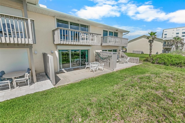 4777 S Atlantic Ave Unit B2, Port Orange, FL 32127 - back of property featuring stucco siding, a patio area, and a lawn