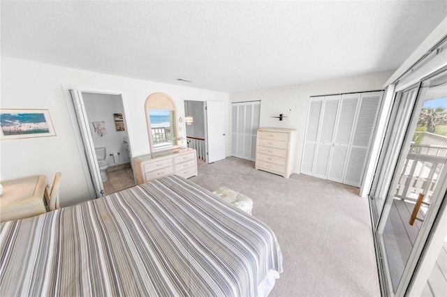 4777 S Atlantic Ave Unit B2, Port Orange, FL 32127 - bedroom with multiple windows, multiple closets, light colored carpet, a textured ceiling, and connected bathroom