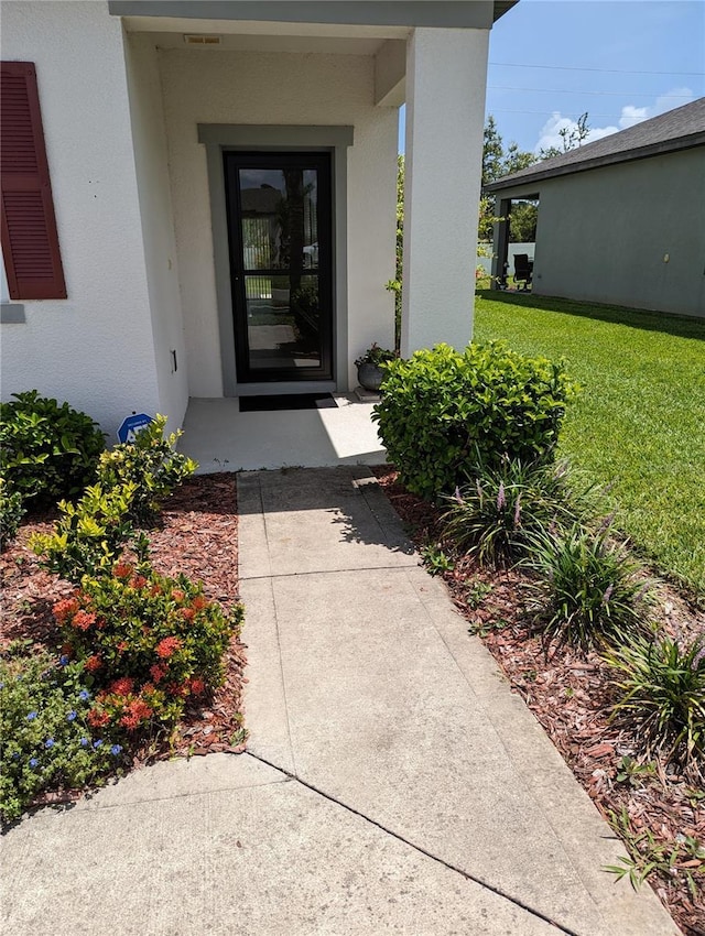 3103 Nova Scotia Way, New Smyrna Beach, FL 32168 - doorway to property featuring stucco siding and a yard