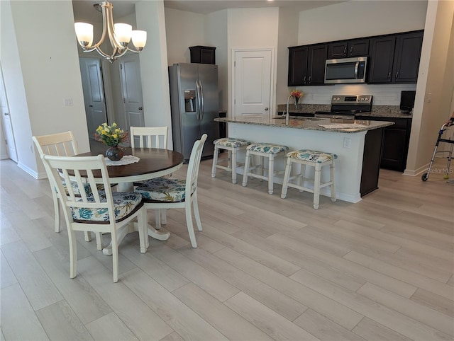 3103 Nova Scotia Way, New Smyrna Beach, FL 32168 - dining room featuring light wood finished floors and a chandelier