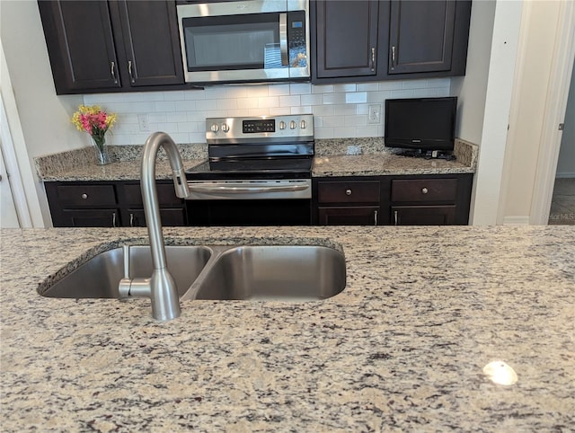 3103 Nova Scotia Way, New Smyrna Beach, FL 32168 - kitchen with appliances with stainless steel finishes, tasteful backsplash, and light stone countertops
