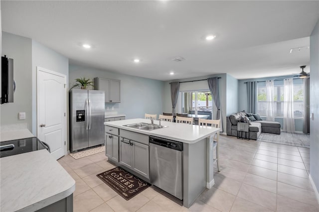 2731 Neverland Dr, New Smyrna Beach, FL 32168 - kitchen with stainless steel appliances, gray cabinetry, light countertops, open floor plan, and light tile patterned floors