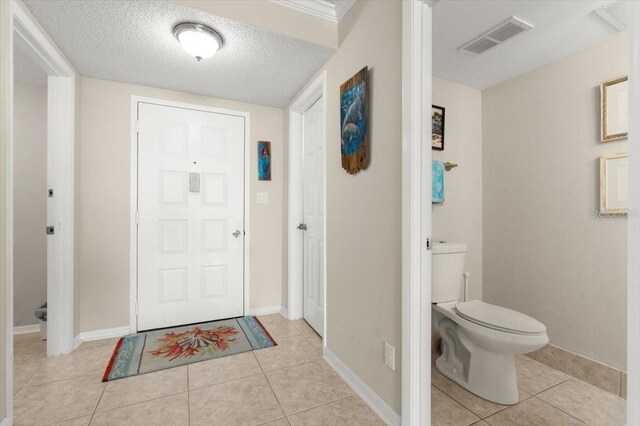 901 S Atlantic Ave Unit 202, Ormond Beach, FL 32176 - foyer entrance with light tile patterned flooring and a textured ceiling
