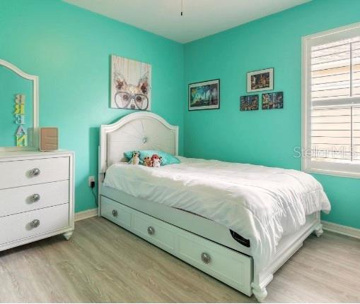 2672 Star Coral Ln, New Smyrna Beach, FL 32168 - bedroom with light wood-style floors and multiple windows