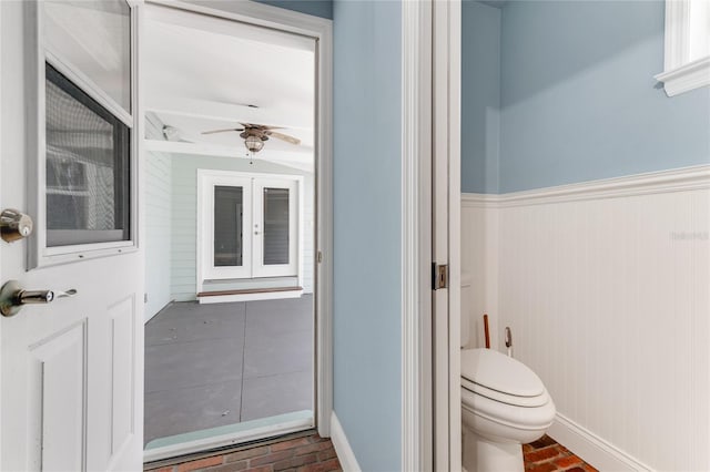 2360 Mooneyham Dr, New Smyrna Beach, FL 32168 - bathroom with brick flooring, a ceiling fan, wainscoting, and french doors