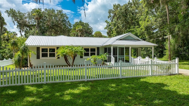 2360 Mooneyham Dr, New Smyrna Beach, FL 32168 - view of front facade featuring a sunroom, a fenced front yard, and a metal roof