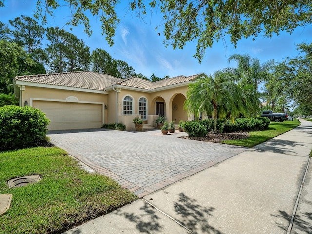 461 Luna Bella Ln, New Smyrna Beach, FL 32168 - mediterranean / spanish-style home featuring decorative driveway, a garage, stucco siding, and a tiled roof