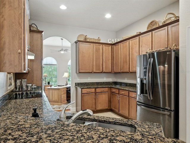 461 Luna Bella Ln, New Smyrna Beach, FL 32168 - kitchen featuring stainless steel fridge with ice dispenser, black electric cooktop, exhaust hood, a ceiling fan, and dark stone countertops