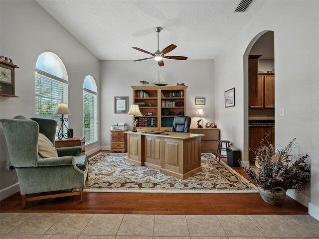 461 Luna Bella Ln, New Smyrna Beach, FL 32168 - office space featuring ceiling fan, vaulted ceiling, a textured ceiling, light wood-style floors, and arched walkways