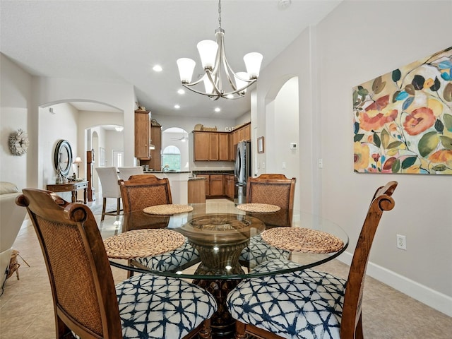 461 Luna Bella Ln, New Smyrna Beach, FL 32168 - dining space with arched walkways, a chandelier, recessed lighting, and light tile patterned floors