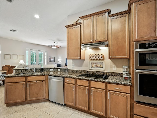 461 Luna Bella Ln, New Smyrna Beach, FL 32168 - kitchen featuring appliances with stainless steel finishes, under cabinet range hood, a peninsula, dark stone countertops, and open floor plan