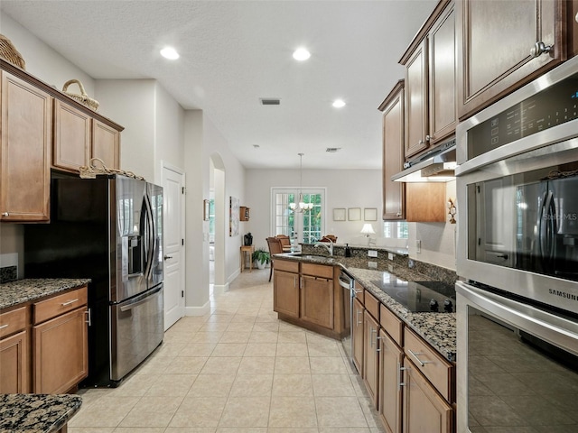 461 Luna Bella Ln, New Smyrna Beach, FL 32168 - kitchen featuring appliances with stainless steel finishes, recessed lighting, a peninsula, a chandelier, and dark stone counters