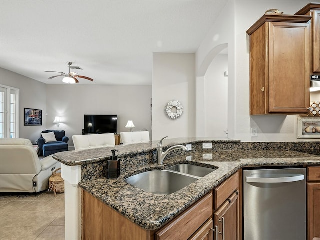 461 Luna Bella Ln, New Smyrna Beach, FL 32168 - kitchen featuring dishwasher, brown cabinetry, ceiling fan, and dark stone counters