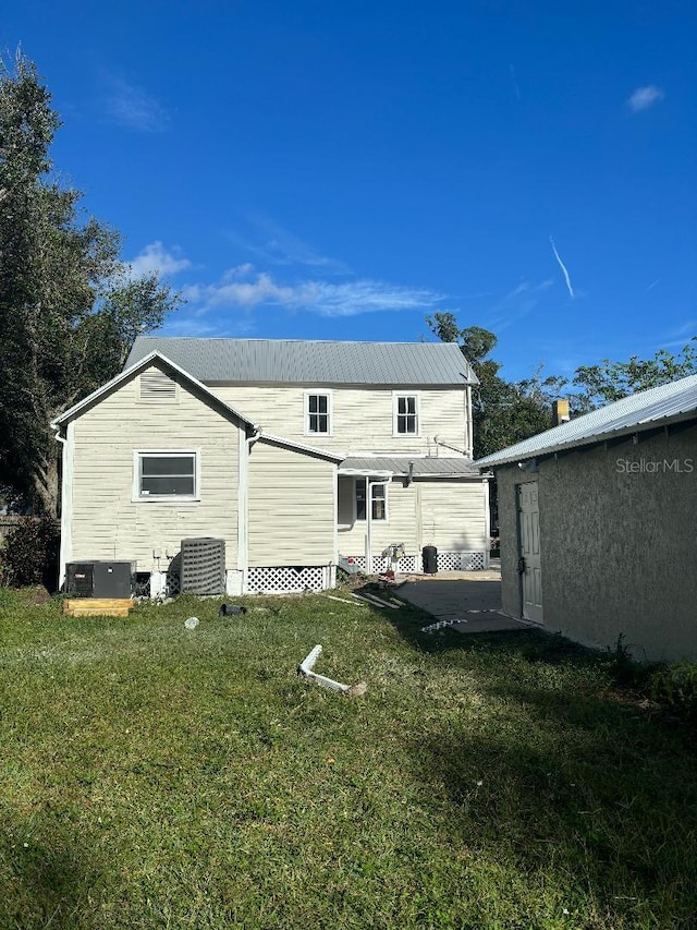 306 Murray St, New Smyrna Beach, FL 32168 - rear view of property featuring a lawn