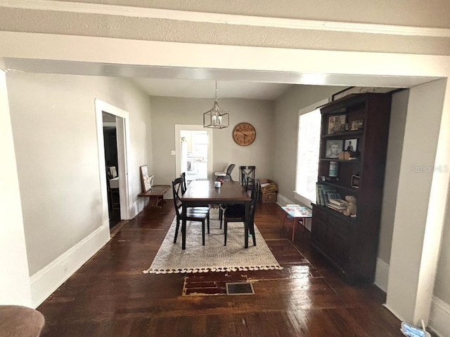 306 Murray St, New Smyrna Beach, FL 32168 - dining room with dark wood-style floors and a chandelier