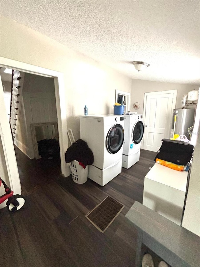 306 Murray St, New Smyrna Beach, FL 32168 - washroom with water heater, washer and dryer, dark wood-style floors, and a textured ceiling