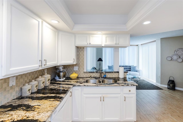 1 Oceans W Blvd Unit 1B5, Daytona Beach, FL 32118 - kitchen with decorative backsplash, a peninsula, light stone countertops, white cabinetry, and recessed lighting