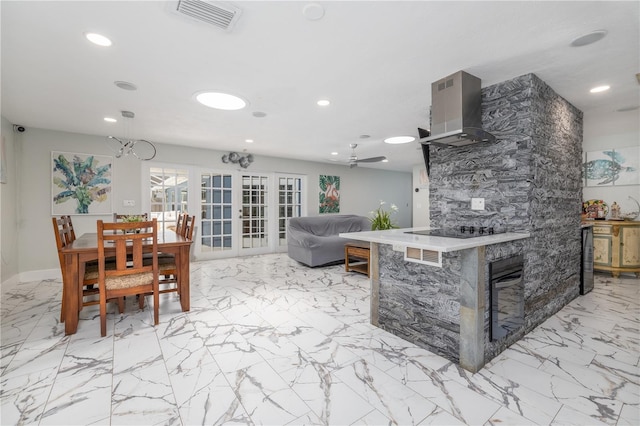 38 Fairway Cir, New Smyrna Beach, FL 32168 - kitchen with island range hood, light marble finish flooring, recessed lighting, french doors, and light countertops
