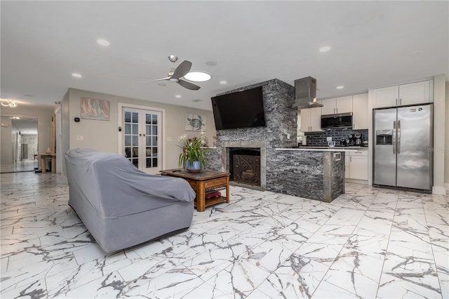 38 Fairway Cir, New Smyrna Beach, FL 32168 - living room with french doors, ceiling fan, recessed lighting, light marble finish floors, and a stone fireplace