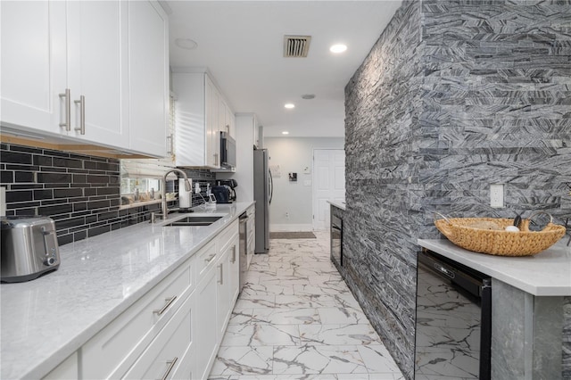 38 Fairway Cir, New Smyrna Beach, FL 32168 - kitchen with appliances with stainless steel finishes, recessed lighting, light marble finish flooring, white cabinets, and tasteful backsplash