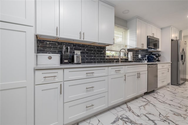 38 Fairway Cir, New Smyrna Beach, FL 32168 - kitchen featuring stainless steel appliances, light marble finish floors, backsplash, white cabinets, and light countertops