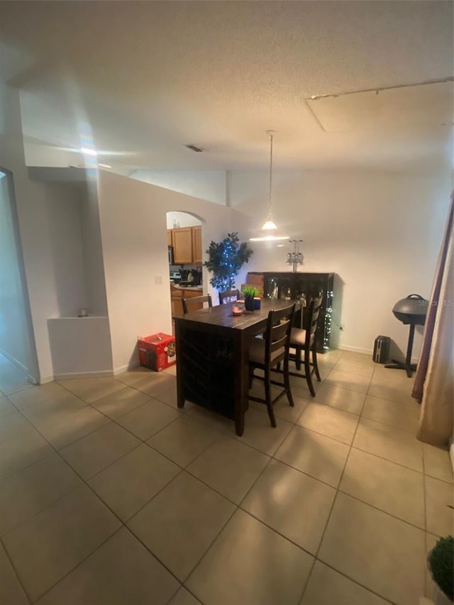 2122 Orange Tree Dr, Edgewater, FL 32141 - dining area with light tile patterned floors, arched walkways, and a textured ceiling