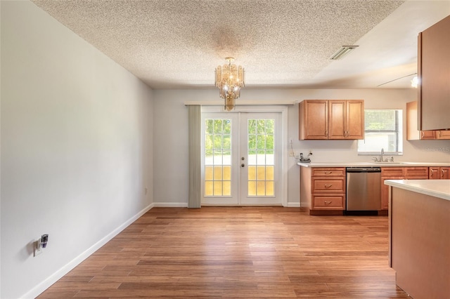 5060 Audubon Ave, De Leon Springs, FL 32130 - kitchen featuring dishwasher, light countertops, healthy amount of natural light, light wood finished floors, and a textured ceiling