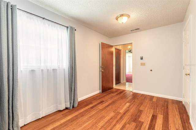 5060 Audubon Ave, De Leon Springs, FL 32130 - spare room with light wood-type flooring and a textured ceiling