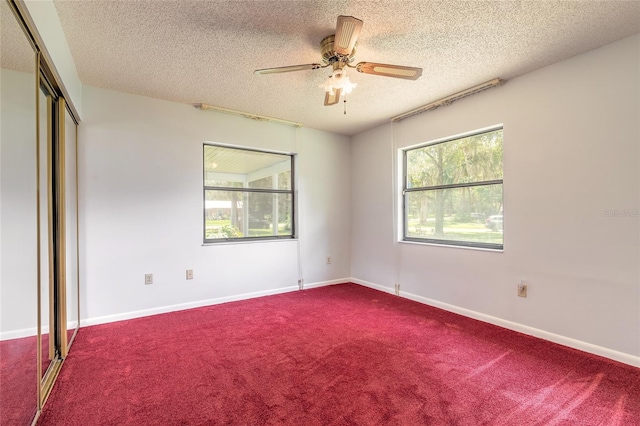 5060 Audubon Ave, De Leon Springs, FL 32130 - unfurnished bedroom with a textured ceiling, carpet flooring, a closet, and a ceiling fan