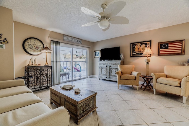 3700 S Atlantic Ave Unit 108, New Smyrna Beach, FL 32169 - living room featuring a textured ceiling, light tile patterned floors, ceiling fan, and a fireplace