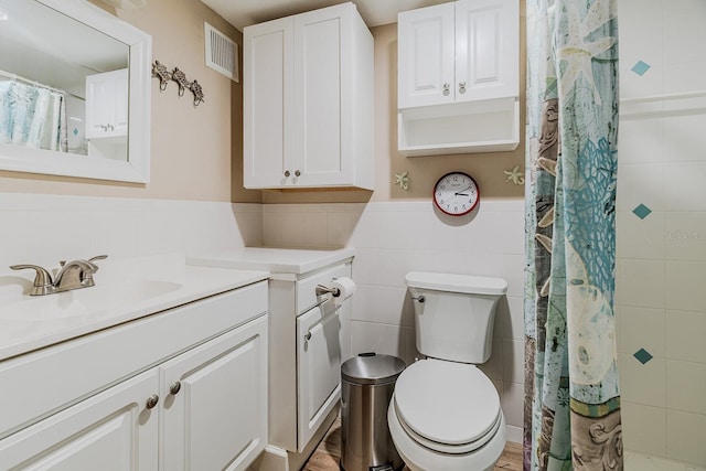 3700 S Atlantic Ave Unit 108, New Smyrna Beach, FL 32169 - full bathroom with vanity, tile walls, a wainscoted wall, and a shower with shower curtain
