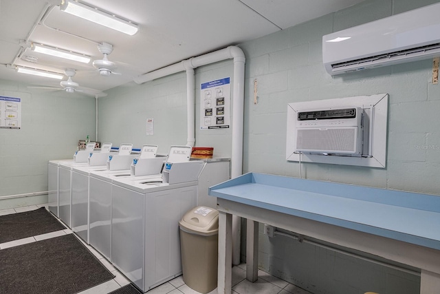 3700 S Atlantic Ave Unit 108, New Smyrna Beach, FL 32169 - communal laundry room with a wall mounted air conditioner, washing machine and clothes dryer, concrete block wall, light tile patterned flooring, and an AC wall unit